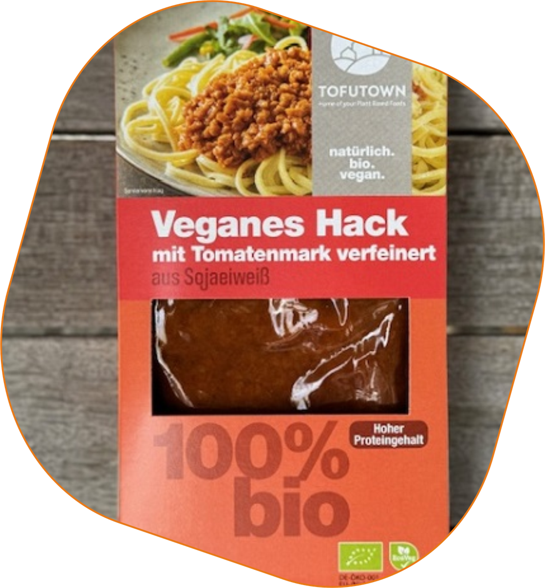 KI generiert: Die Verpackung zeigt ein Produkt namens "Veganes Hack", das aus Sojaeiweiß besteht und mit Tomatenmark verfeinert ist. Es ist biologisch hergestellt und hat einen hohen Proteingehalt.